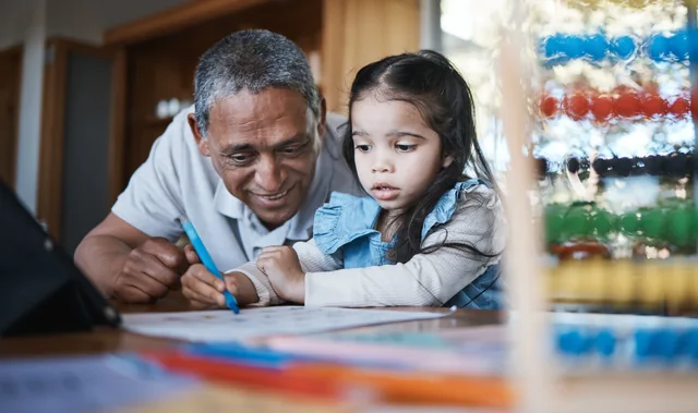 Un adulto y una niña dibujan juntos.